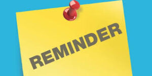 a yellow notice tacked to a bulletin board that says "reminder"