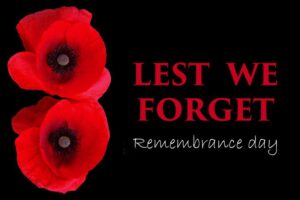 Black Background with red poppies on left lside with the caption "Lest We forget Remembrance Day"